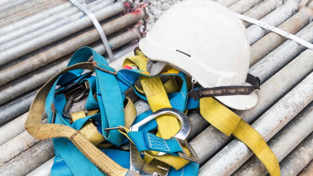 safety-helmet-and-safety-harness-at-a-construction-P87EPBK